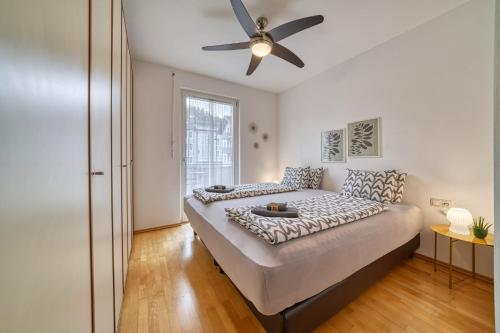 1 dormitorio con 1 cama y ventilador de techo en City Café - CENTRAL Apartment, en Brunico