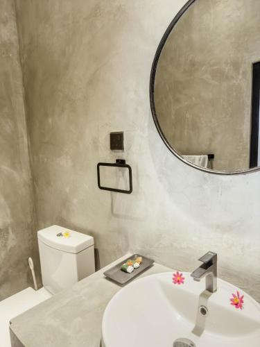 un baño con lavabo y espejo en Alice in Paradise, en Unawatuna