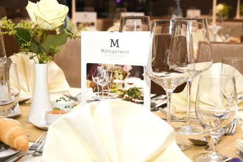 a table with wine glasses and flowers on it at Hotel Metzgerwirt in Sankt Veit im Pongau