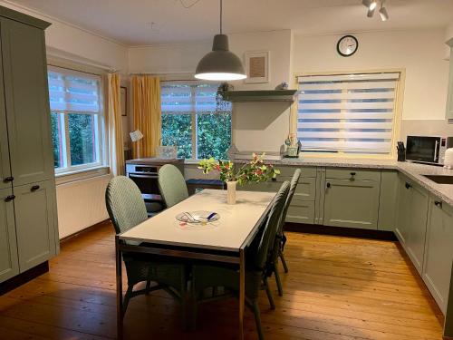 a kitchen with a table and chairs in a kitchen at Landgoed De Heezeberg in Diever