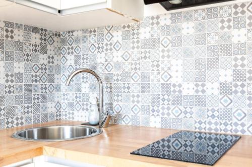 a kitchen with a sink and a tile wall at Montmartre Aparts 2 individual studios in Paris