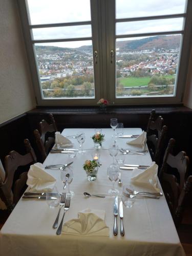 a table with a white table cloth and silverware at Eventlocation & Hotel Schloss Neuburg in Obrigheim