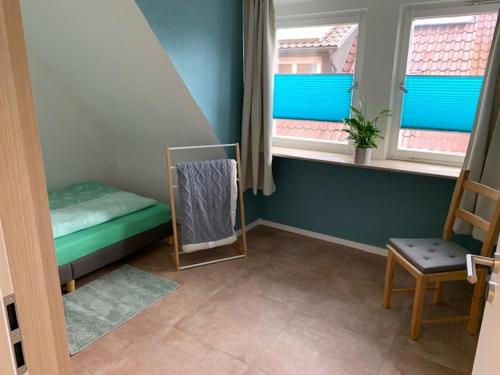 a small room with a bed and two windows at Hofesh in Altdorf