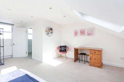 a white room with a desk and a chair at Stunning S/Wimbledon Flat w/parking in London, Uk in London