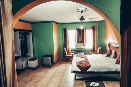 a bedroom with green walls and a bed in a room at The Avantika Hotel & Woodland Restaurant in Gorakhpur