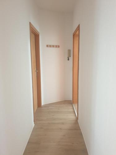 an empty hallway with two doors and a wooden floor at Zur Altstadt in Plauen