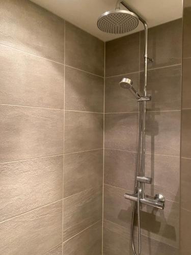 a shower with a shower head in a bathroom at Familyroom #1 Appartmenthotel Oslo Adress Isabels vei 16 in Oslo