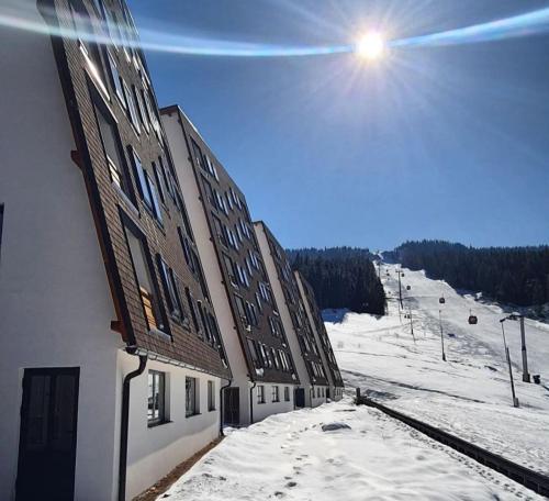 a building in the snow next to a ski slope at Diego - Ravna planina in Pale