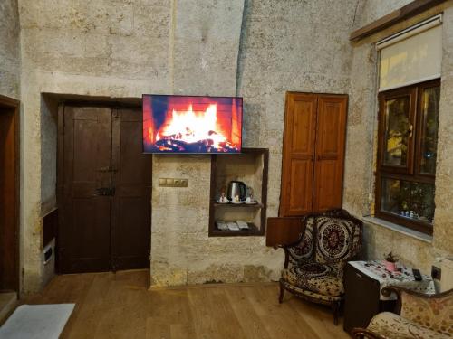 a living room with a tv and a chair at Born Hotel in Urgup