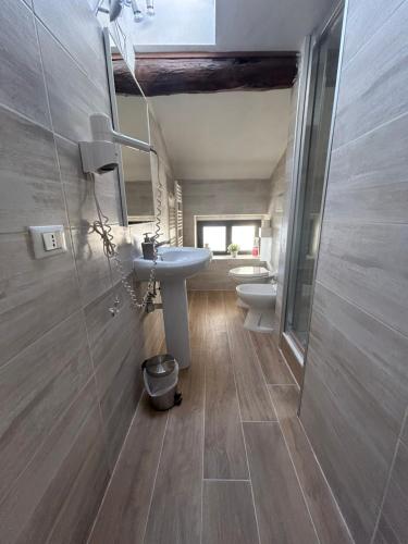 La salle de bains est pourvue d'un lavabo et de toilettes. dans l'établissement B&B Magnolia, à Vérone