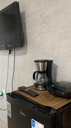 uma televisão em cima de um computador com comodidades para preparar café em Chalé das flores lírio em São Miguel do Gostoso