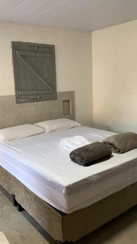 uma grande cama branca num quarto com em Chalé das flores lírio em São Miguel do Gostoso