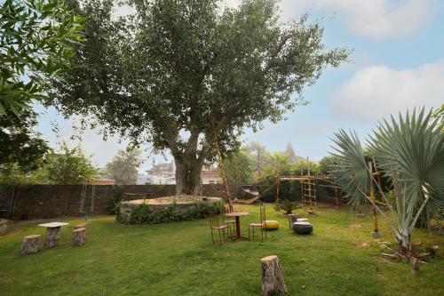 a garden with a tree and a table in the grass at Fort Beejwar Chauhan by AAYAMs Neemrana in Shāhjahānpur