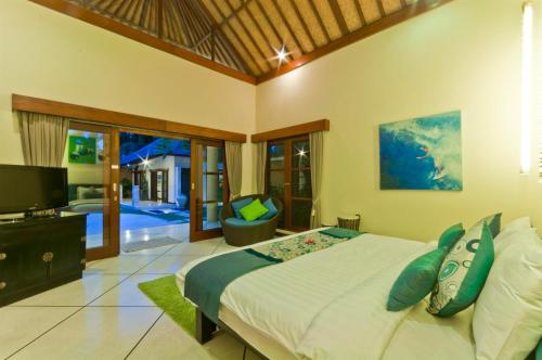 a bedroom with a large bed and a tv in it at Villa Mango - 3 Bedroom Villa in Seminyak in Seminyak