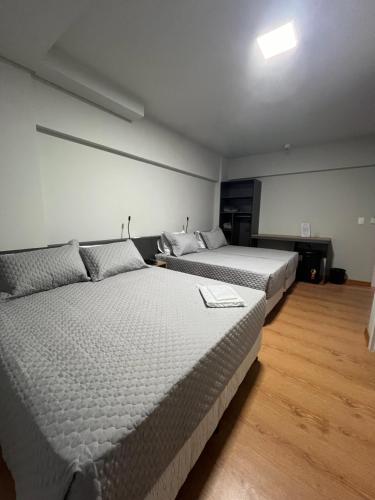 a bedroom with two beds in a room at Hoteis Cattoni in Lages