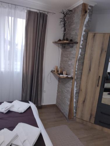 a bedroom with a bed and a brick wall at Lela Kop in Kopaonik