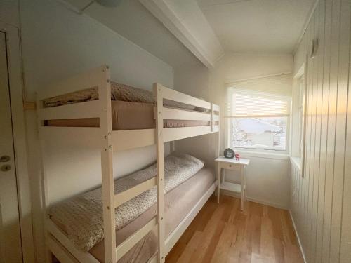two bunk beds in a small room with a window at Koselig leilighet med fantastisk utsikt in Tromsø