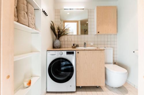 y baño con lavabo y lavadora. en Kaluri Seaview Apartment, en Kuressaare