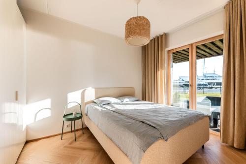 a bedroom with a bed and a large window at Kaluri Seaview Apartment in Kuressaare