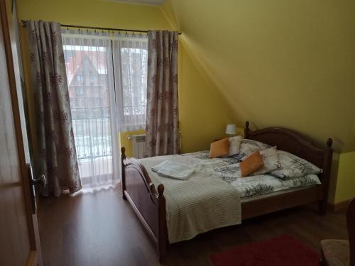 a bedroom with a bed and a large window at Bębenkowie in Białka Tatrzanska