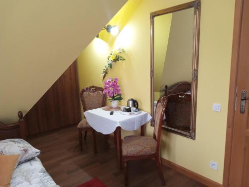 a small table with chairs and a mirror in a room at Bębenkowie in Białka Tatrzanska