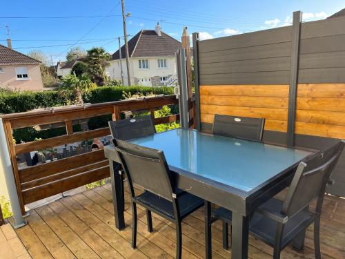 une table bleue et des chaises sur une terrasse dans l'établissement Maison à 700m de la plage, à Courseulles-sur-Mer