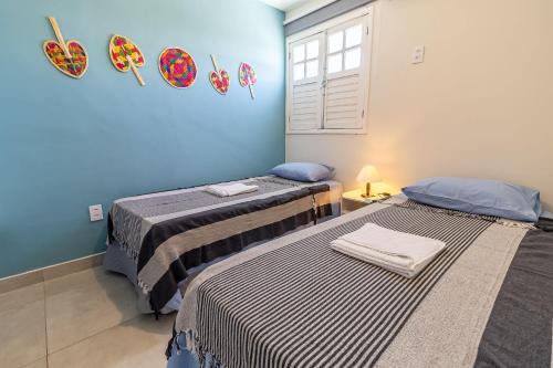 2 camas en una habitación con paredes azules en Encanto do Francês (4 minutos, a pé, da Praia) en Praia do Frances