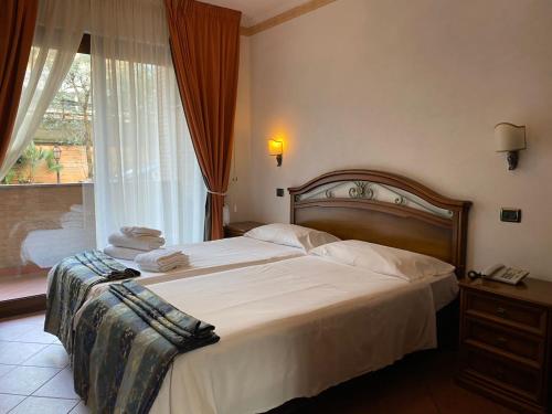 a bedroom with a large bed and a window at EURO HOUSE INN airport in Fiumicino