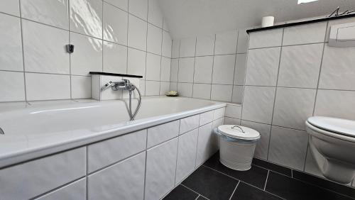 ツィノヴィッツにあるUsedom Suites Zinnowitzの浴槽とトイレのある白いバスルーム