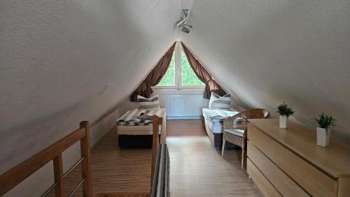 a attic room with a bed and a window at Usedom Suites Zinnowitz in Zinnowitz