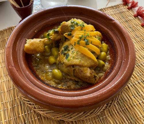 a bowl of food with chicken and peas and carrots at Residence Chay - Luxury Appart in Ouarzazate