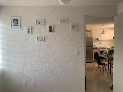 - un mur blanc dans une cuisine avec des photos dans l'établissement Cómodo Departamento con Ubicación privilegiada, 