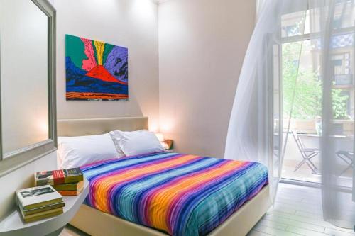 Residenza Suarez في نابولي: سرير ملون في غرفة مع نافذة