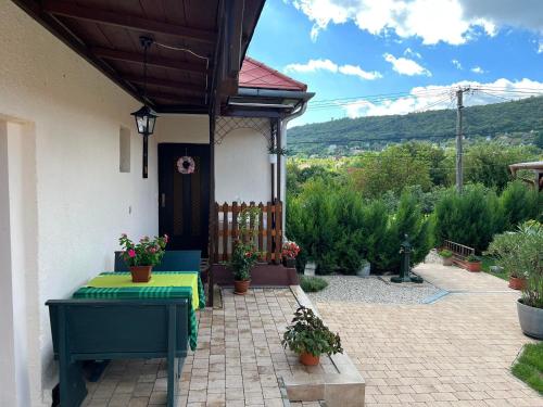 a patio with a table and a fence and some plants at Becehegyi Vendégház in Balatongyörök