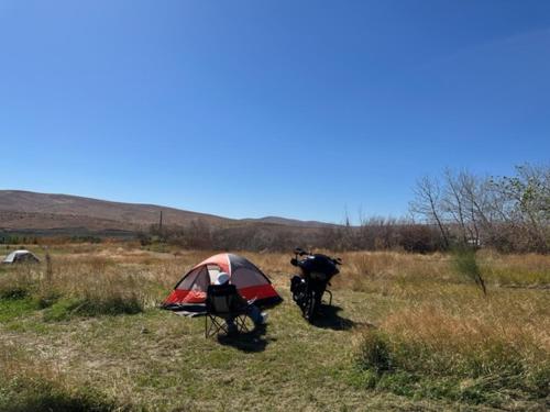 a tent and a motorcycle parked in a field at Infidel Acres Motorcycle camping in Naches