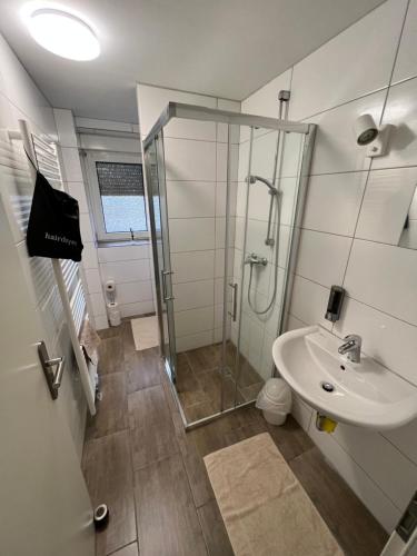 ein Bad mit einer Dusche und einem Waschbecken in der Unterkunft Pluto in Gelsenkirchen