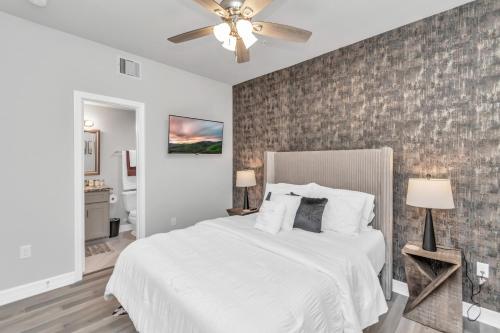 a bedroom with a white bed and a brick wall at TEXAS-Style 2 BR Apartment near NRG Stadium, University of Houston, Med Center, Gated, Wifi, Parking in Houston