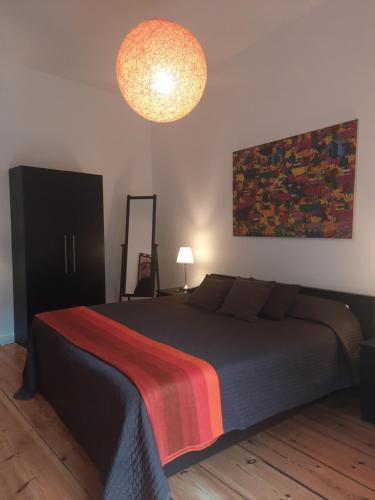 - une chambre avec un lit et une couverture colorée dans l'établissement Berlin Apartments Mitte, à Berlin