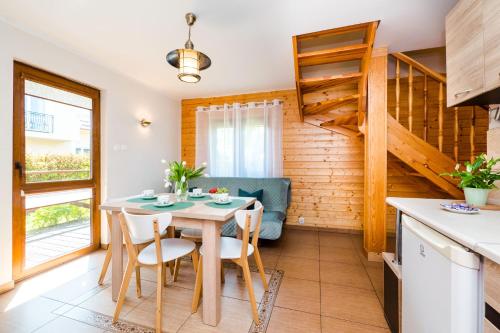 a kitchen and dining room with a table and chairs at Morskie Chaty Platanowa in Rowy