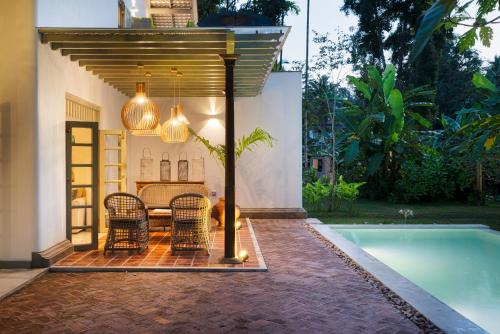a patio with a table and chairs next to a pool at Sukomala Imaduwa in Ahangama