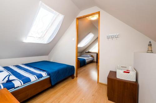 a attic bedroom with a bed and a mirror at Morskie Chaty Platanowa in Rowy