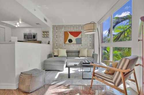 a living room with a couch and a table at Treetop Retreat! Cozy 2 Bedroom In Heart Of Grove in Miami
