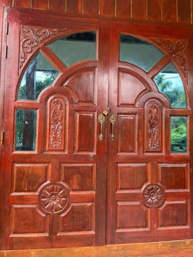 een houten deur met twee ramen erop bij Nuree Villa & Bungalow in Phra Ae beach