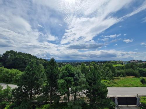 a view of trees and a sky with clouds at La Casa De Roland in Wieliczka