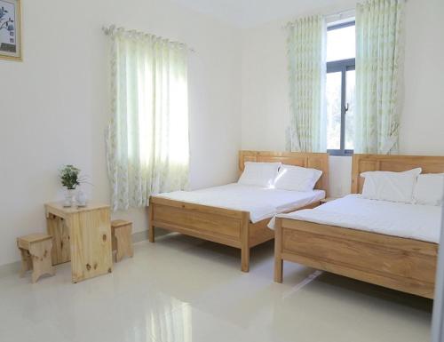 a bedroom with two twin beds and a window at Iris Hotel in Cái Răng