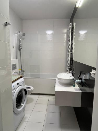 Un baño con lavadora y lavabo. en cybernetyki2 INN near airport, en Varsovia