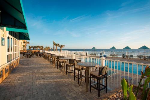 a row of tables and chairs next to the beach at SpringHill Suites by Marriott New Smyrna Beach in New Smyrna Beach