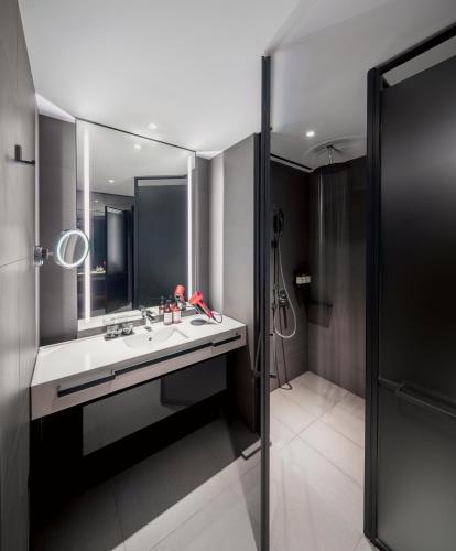 a bathroom with a sink and a mirror at Fraser Residence River Promenade, Singapore in Singapore