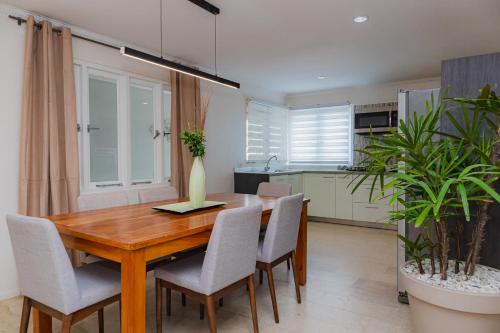 a kitchen and dining room with a wooden table and chairs at Bubali Residence in Palm-Eagle Beach