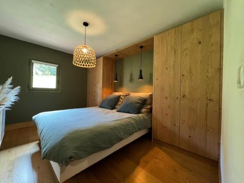 ein Schlafzimmer mit einem Bett mit einer großen Holzwand in der Unterkunft Grand chalet à la montagne in Bourg-Saint-Maurice